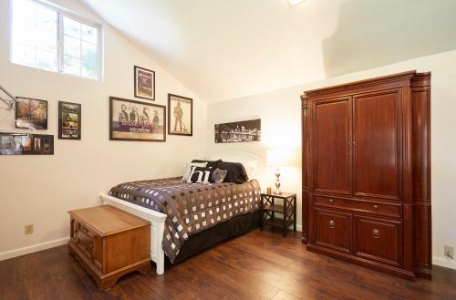 a bedroom with a bed and a wooden cabinet at Willow Glen Private Studio in San Jose