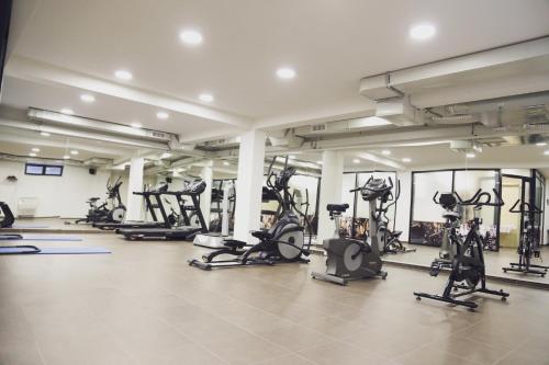 a gym with a lot of exercise equipment in a room at City Hotel in Prizren