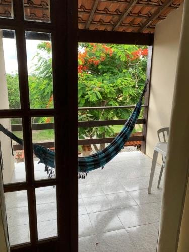a hammock in a room with a view of a garden at Pousada Recanto do Mar in Saquarema