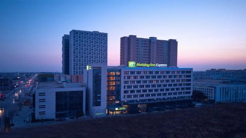 a building with a sign on the top of it at Holiday Inn Express Nantong Textile City by IHG in Tongzhou