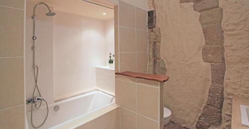 a bathroom with a bath tub and a toilet at Maison de LOlivier, Beautiful Townhouse with Private courtyard in Eymet