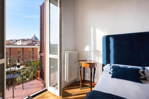 1 dormitorio con 1 cama y balcón en Lovely apartment with balcony, en Florencia