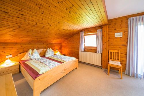 um quarto com uma cama num quarto de madeira em Ferienwohnung Schoberhof em Filzmoos