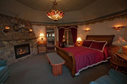 um quarto com uma cama grande e uma lareira em Beaver Valley Lodge em Leavenworth