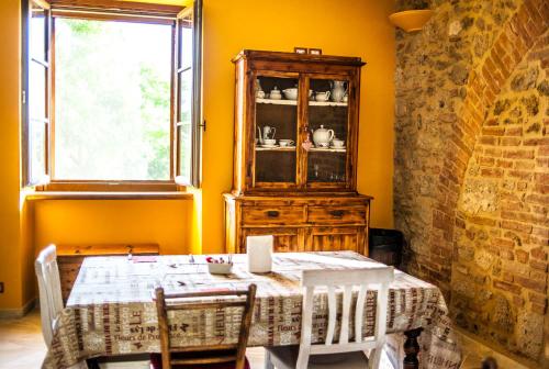 Un comedor con una mesa y una ventana. en Agriturismo Dipinture, en Asciano