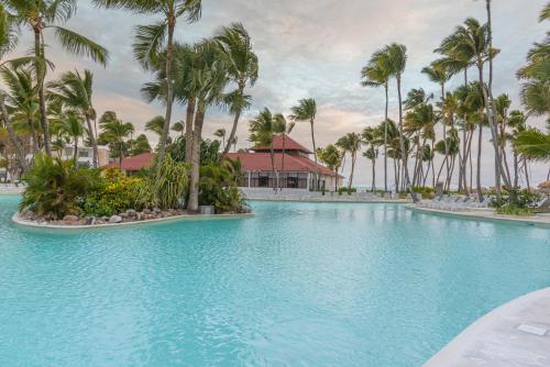 a swimming pool with palm trees in a resort at Grand Bavaro Princess - All Inclusive in Punta Cana