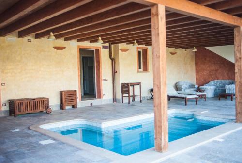 a room with a pool, chairs, and a table at Agriturismo Dipinture in Asciano