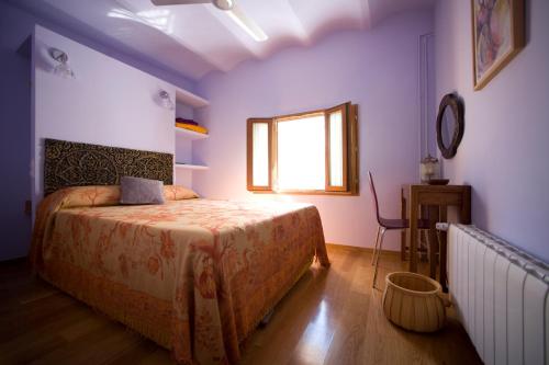 a bedroom with a large bed and a window at Amarain Casa Rural in Gestalgar