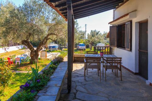 een patio met een tafel en stoelen op een huis bij George`s House in Nikiti