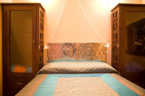 a bedroom with a bed with a wooden headboard at Amarain Casa Rural in Gestalgar
