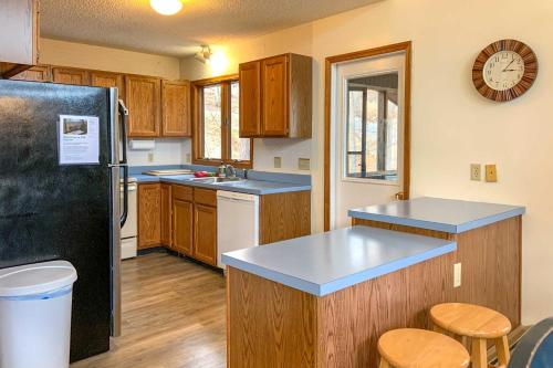 a kitchen with a black refrigerator and wooden cabinets at The Overlook in Massanuttens All Season Resort in McGaheysville
