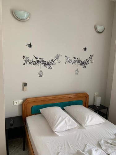 パルガにあるPansion Olgaのベッドルーム1室(白いシーツと壁に鳥が飾られたベッド1台付)