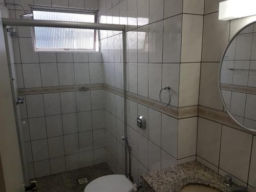 a bathroom with a toilet and a mirror at Hotel Blumenau - Balneário Camboriú in Balneário Camboriú