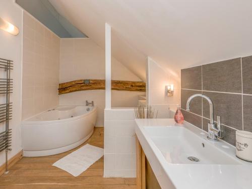 a bathroom with a bath tub and a sink at Flint Barn in North Walsham