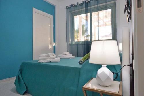a blue bedroom with a bed with towels on it at Scala dei Turchi Luxury Home in Realmonte