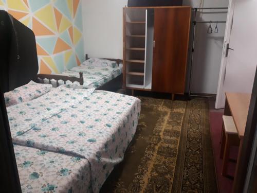 ein Schlafzimmer mit 2 Betten und einer Kommode darin in der Unterkunft Triangle in Sarajevo