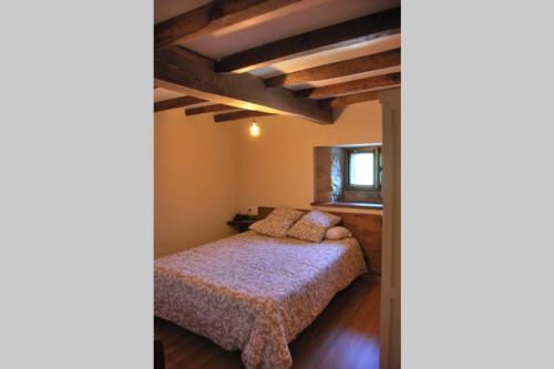 a bedroom with a bed in a room with wooden floors at LA CASITA VERDE in Onís