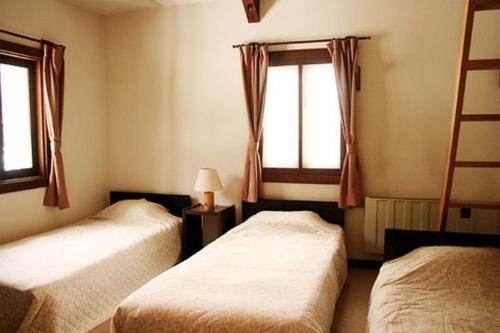 a bedroom with two beds and a window at Earl Grey in Hakuba