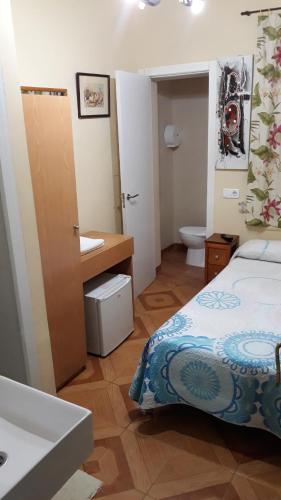 y baño con cama, lavabo y aseo. en Hostal Fuentesol, en Madrid