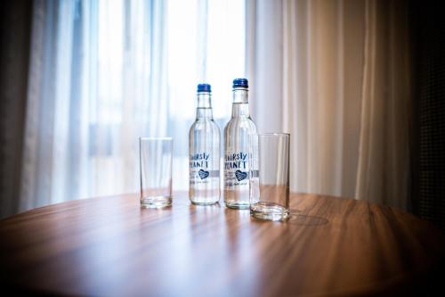 two bottles and two glasses on a wooden table at The Warwickshire Hotel and Country Club in Warwick