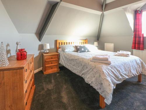 ein Schlafzimmer mit einem Bett, einer Holzkommode und einer Kommode in der Unterkunft Royal Oak in Matlock