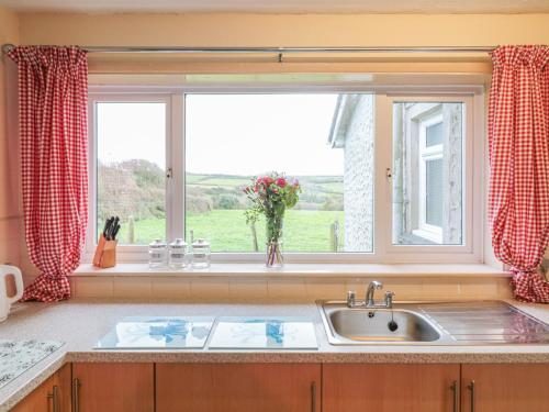 una cucina con lavandino e finestra di Underlanes a Camelford