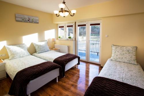 a room with three beds and a window at Rancho Ulinia koło Łeby in Ulinia