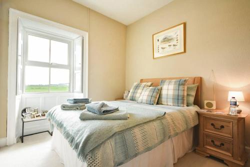 a bedroom with a bed with a window and a dresser at Rocking Chair Farmhouse in Alnwick