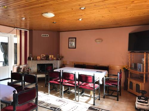 a dining room with a table and chairs and a tv at Vasilevi House in Devin