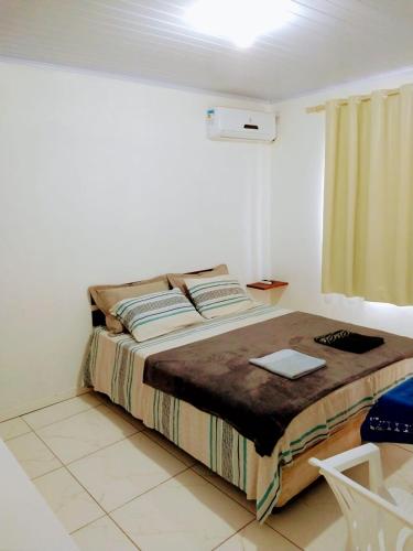 a bedroom with a bed in a white room at Residencial Dona Duda in Bombinhas