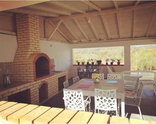 a patio with a brick fireplace and a table and chairs at Pensiunea Grădina Ascunsa in Bughea de Jos