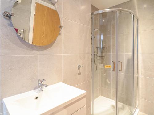 een badkamer met een douche, een wastafel en een spiegel bij Little Lanes in Camelford
