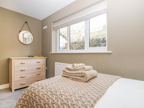 a bedroom with a bed with a blanket and a window at Bishop Fell in Newby Bridge