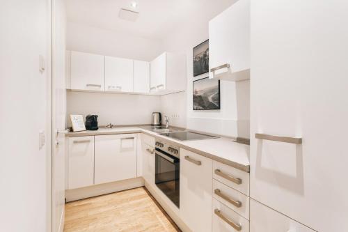a white kitchen with white cabinets and a sink at TIP! Modernes Apartment direkt im Herzen Dresdens in Dresden