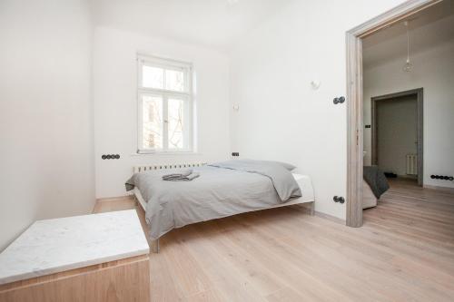 Habitación blanca con cama y espejo en Ascetic Skolas Street Apartment en Riga