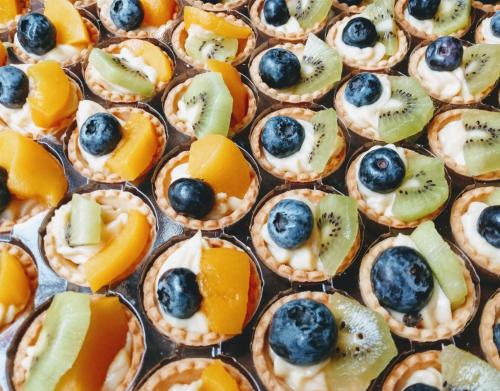 Une bande de mini-tartes avec des fruits sur elles. dans l'établissement Calvy, à Genève