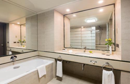a bathroom with a tub and a large mirror at InterContinental Santiago by IHG in Santiago