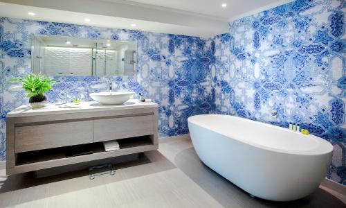 a blue and white bathroom with a tub and a sink at InterContinental Santiago by IHG in Santiago
