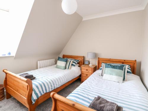 two twin beds in a room with a attic at Little Wash Cottage in Hunstanton