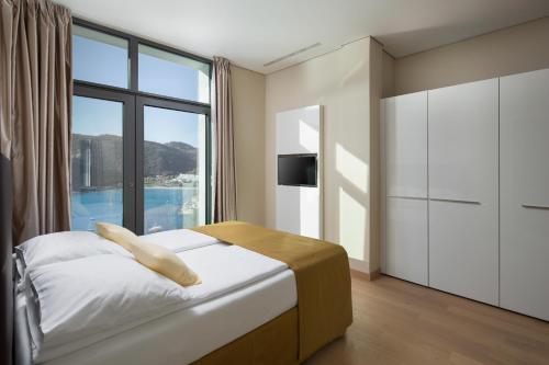 a bedroom with a bed and a large window at Luxury Apartment Istra Rabac - Penthouse RAB in Rabac