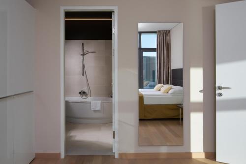 ein Bad mit einer Badewanne und ein Schlafzimmer in der Unterkunft Luxury Apartment Istra Rabac - Penthouse RAB in Rabac