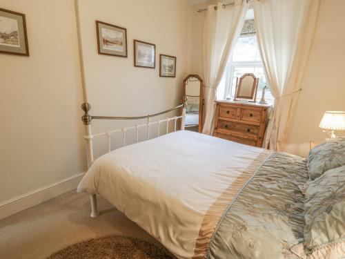 a bedroom with a bed and a dresser and a window at Manod View in Blaenau-Ffestiniog