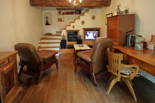 a living room with chairs and a desk and stairs at Domaine de Malouziès in Fontiers-Cabardès