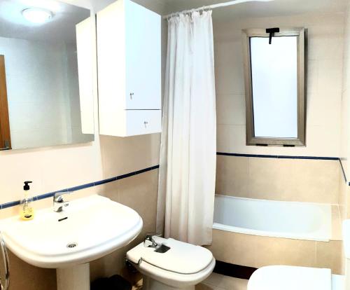 bagno con lavandino, servizi igienici e finestra di Los Locos Beach Apartments a Torrevieja