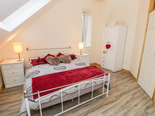 a bedroom with a bed with red pillows at Ffynnon Bach in Caernarfon