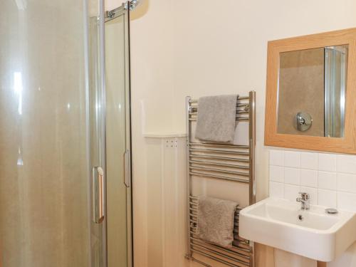 a bathroom with a shower and a sink at The Shippon in Axminster