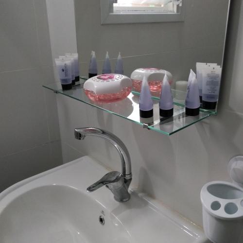 a bathroom with a sink and a shelf with cakes at "הפינה שלי בטבריה" in Tiberias