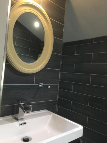 a bathroom with a white sink and a mirror at Hazel Manor in Harrogate