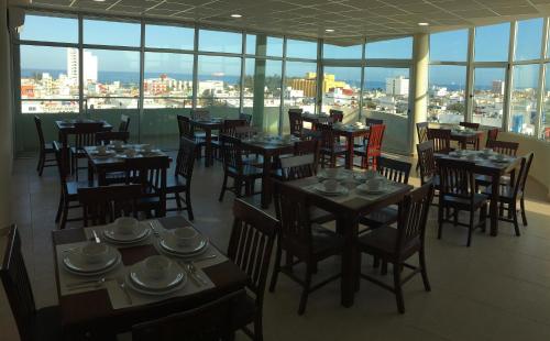 a restaurant with tables and chairs with a view of the city at Harbour Inn - Veracruz in Veracruz