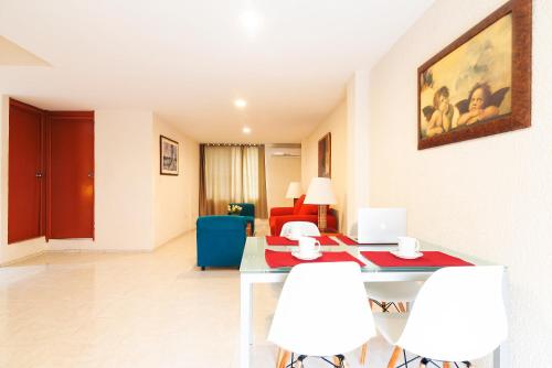 a living room with a table and white chairs at Hotel y Suites Nader in Cancún